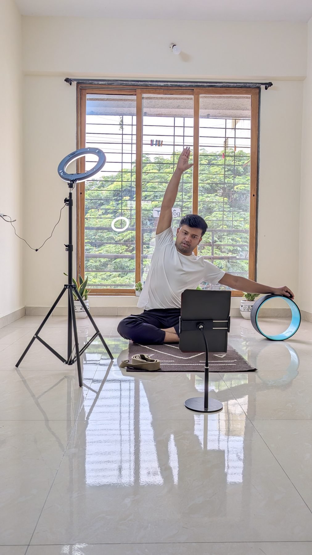 Yogi Gajendra demonstrating a seated side stretch during a home practice session